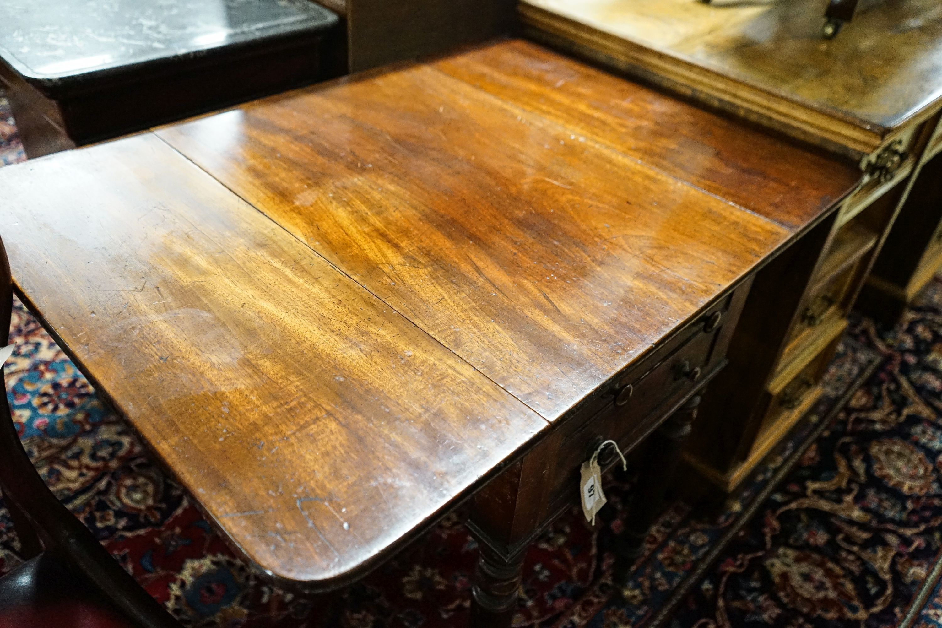 An early Victorian mahogany Pembroke work table, with twin flaps, two drawers, on turned legs and castors, 85cm extended, depth 61cm, height 70cm